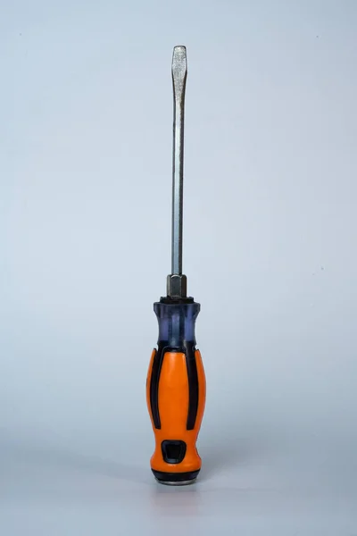 Orange-handled screwdriver isolated on white background. Simple composition, professional tool photo for repair, DIY, or hardware use. 
