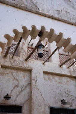 Close-up of carved wooden corbel and eave detail in Al Seef, highlighting craftsmanship and traditional architectural ornamentation. 