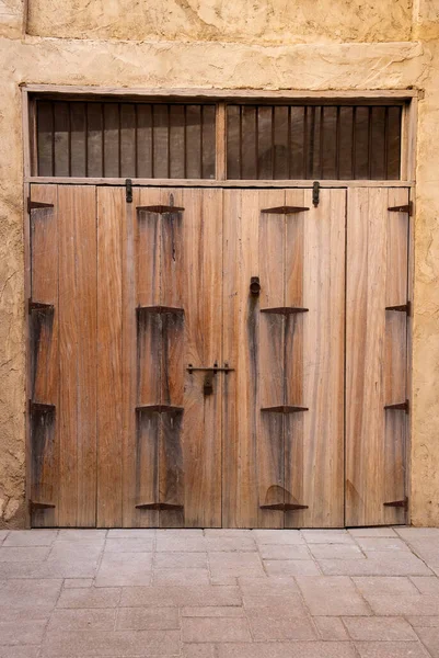 Dubai, BAE 'deki eski Arap ahşap kapıları ve kil duvar.. 