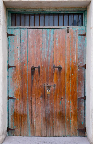 Paslı ve soluk mavi boyalı eskimiş metal kapılar, zamanı ve endüstriyel güzelliği simgeleyen soyut bir doku yaratıyor.. 