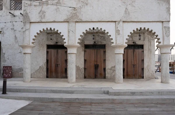 Al Seef miras bölgesinde, kemerli ahşap kapıları ve kum renkli duvarları olan tarihi Arap mimarisi..