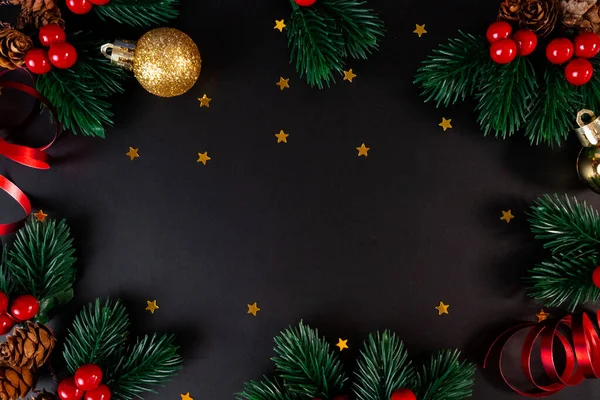 Altın ve kırmızı süslemeleri, çam dalları ve karşılama metinleri için kopya alanı olan zarif bir koyu renk Noel arkaplanı.. 