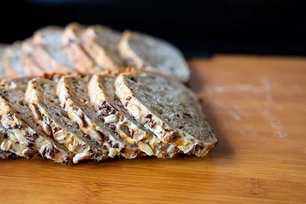 Görünür tohumlar ve kırsal kabuklu çoklu hububat somunu yakın plan, doğal ışık altında fotoğraflanmış. Sağlıklı yemek temaları için ideal. 