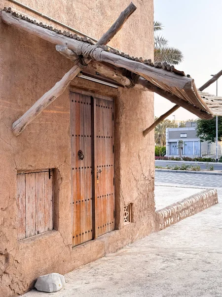 Geleneksel kil binalar arasında dar ahşap dar bir sokak. Köy işçiliği ve Körfez tarzı mimari sergileniyor.. 