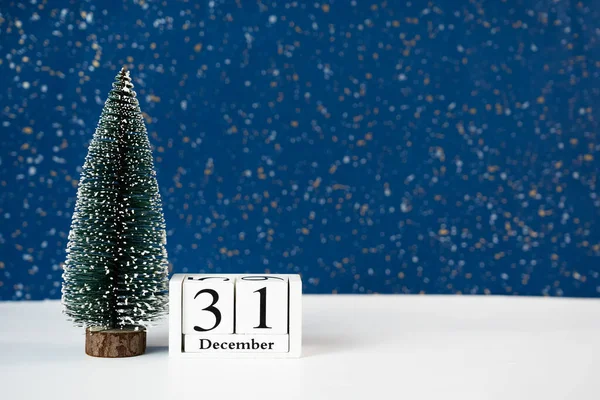 31 Aralık 'ı gösteren ahşap Noel ağacı ve takvimle basit zarif bir kompozisyon. Yılbaşı geri sayımı ve şenlikli pazarlama görselleri için ideal. 