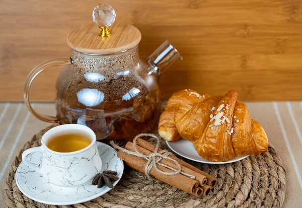 Bir fincan çay, cam çaydanlık ve kruvasanla sıcak bir sabah masası. Sıcak ev yapımı kahvaltı sahnesi. - Evet. Yüksek kalite fotoğraf