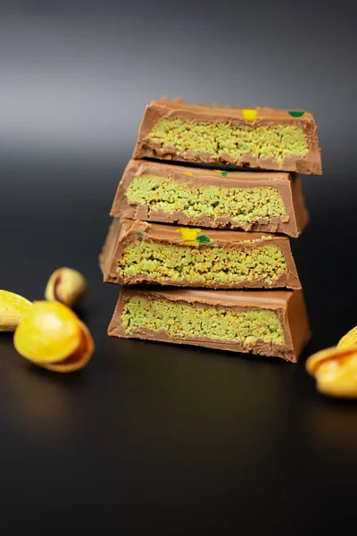 Siyah arka planda fıstıklı çikolatanın sanatsal makro görüntüsü ambalaj, menüler ve lüks markalar için mükemmel bir kare.. 