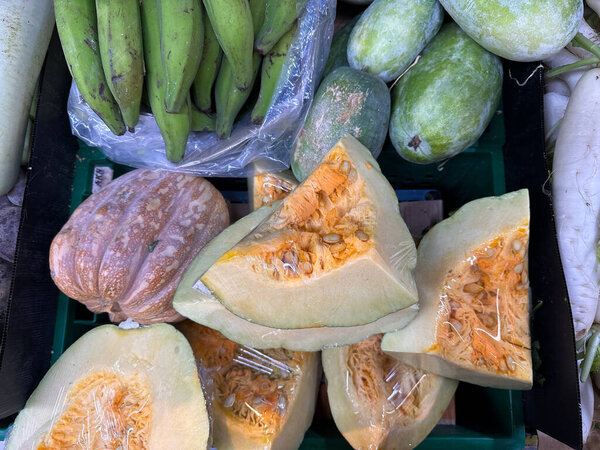 Крупный план спелых тыкв, разрезанных пополам на местном фермерском рынке. Органические тропические продукты концепции, здоровое питание, фермерский образ жизни. 
