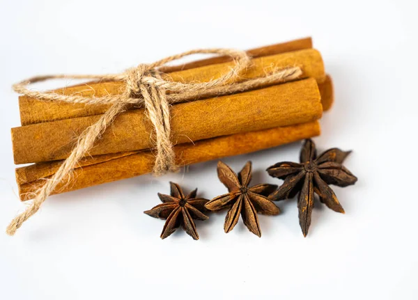 Temiz arkaplanda yıldız anason demeti olan güzel tarçın çubukları. Kış konforu, baharat aroması ve doğal sağlık kavramı.