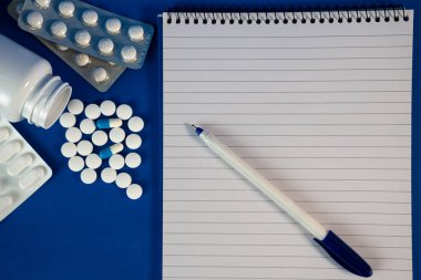 Renkli yüzeyde hap, şişe ve defter düzlüğü var. Sağlık, teletıp ya da eczane markası için harika. Yüksek kalite fotoğraf