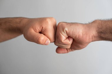 İki elin yakın çekimi yumruk tokuşturuyor. Takım çalışması, birlik, anlaşma ve ortaklığın sembolü. 