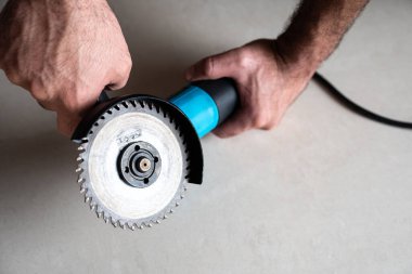 Mavi açı öğütücüsünü kesme diski ile kavrayan eller, DIY öğretileri, güvenlik gösterileri ve ticaret makaleleri için uygun aksiyon-hazır araç çekimi. 