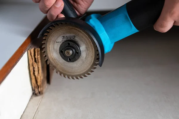 Ahşap çerçevenin yanında çalışan bir açı öğütücü kenarının açılı yakın çekimi, özel küçük resimler, DIY blog başlıkları ve yenileme yazıları için güçlü. 