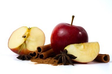 Tarçın çubuklu taze elma dilimleri ve beyaz arka planda izole edilmiş baharatlar. Sıcak sonbahar yemekleri konsepti. Yüksek kalite fotoğraf