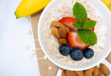 Lezzetli Sağlıklı Yulaf Ezmesi Kasesine Taze Böğürtlen, Badem ve Muz ve Yumuşak Odak Arkaplanda Kahvaltı İçin Muz. Yüksek kalite fotoğraf