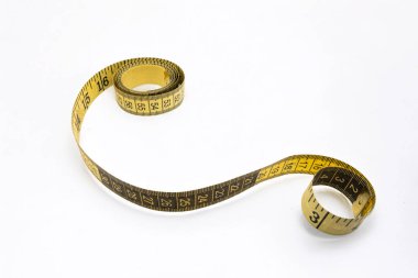 Esnek sarı şeritli, siyah işaretli, sarmalanmış ve açık beyaz arka planda. Yüksek kalite fotoğraf