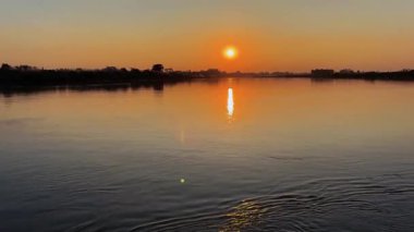 Altın saat nehir yolculuğu, gün ışığı su üzerinde dans, huzurlu kaçış, doğal güzellik, seyahat yeri
