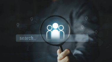 Küresel adam toplama ve yetenek arama konsepti. Dijital arama çubuğu ve dünya haritası arkaplanı olan grup simgesine odaklanan büyüteç. Uluslararası pazar araştırması ve insan kaynakları avı.