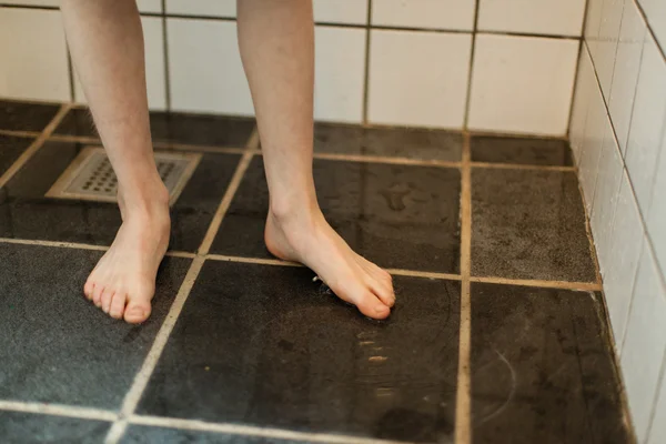 Pieds nus d'un jeune garçon dans une salle de bain à la maison — Photo