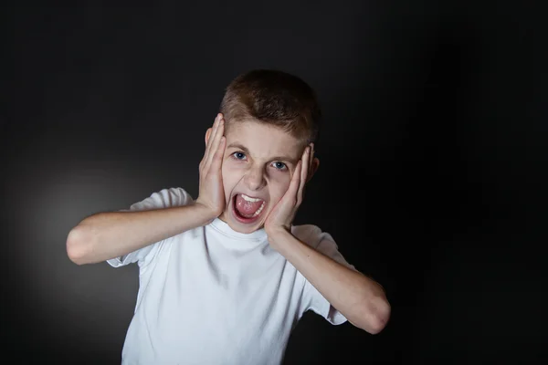 Boze jongen schreeuwen met handen houden op zijn gezicht — Stockfoto