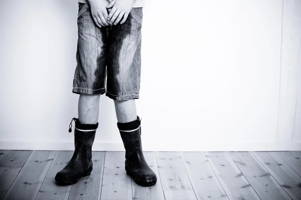 Legs of teenager with wet pants and boots