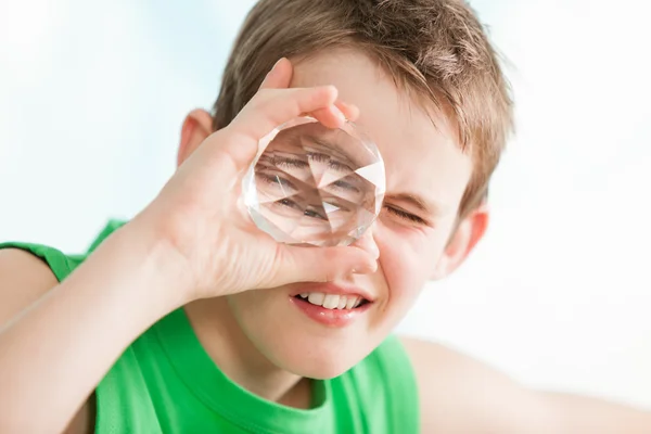 Chlapec s multi tváří krystal proti oko — Stock fotografie