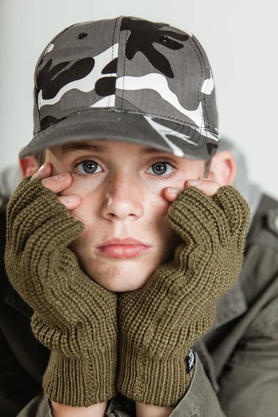 Mannelijke tiener mokkend terwijl gezicht in handschoenen — Stockfoto