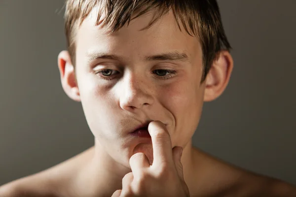 Giovane ragazzo profondo in pensiero mentre succhiare su dito — Foto Stock