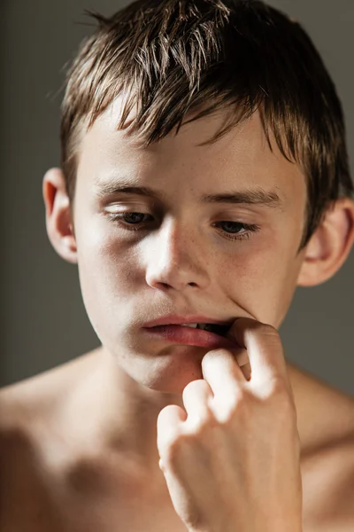 Širá dospívající chlapec vyzvedání zubů prstem — Stock fotografie