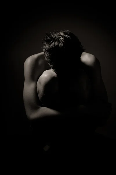 Young Man Huddling on Floor Holding Knees to Chest — Stock Photo, Image