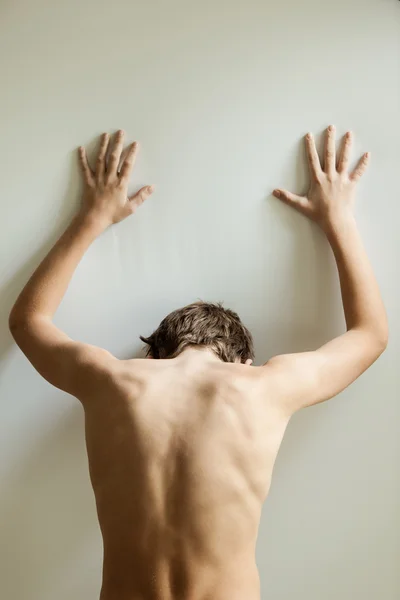 Vertical view on back of teen with hands on wall — Stock Photo, Image