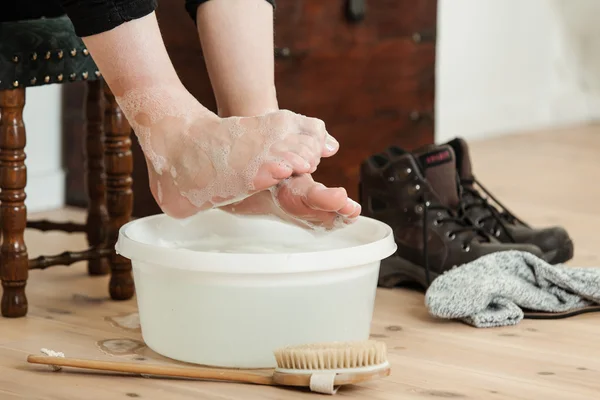 Curled up toes over cold soapy water and brush — Stock Photo, Image