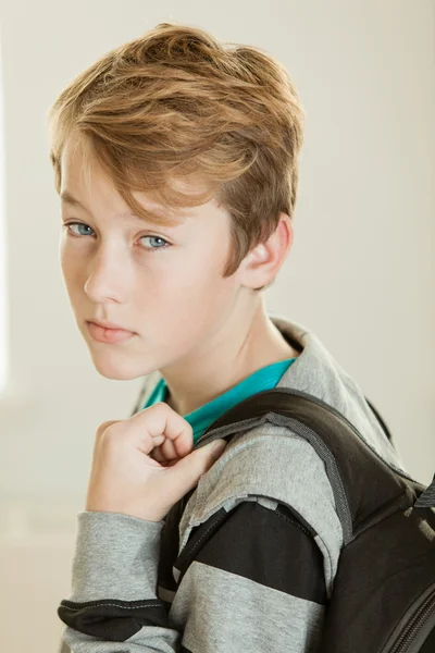 Handsome boy with backpack looking over shoulder — Stock Photo, Image