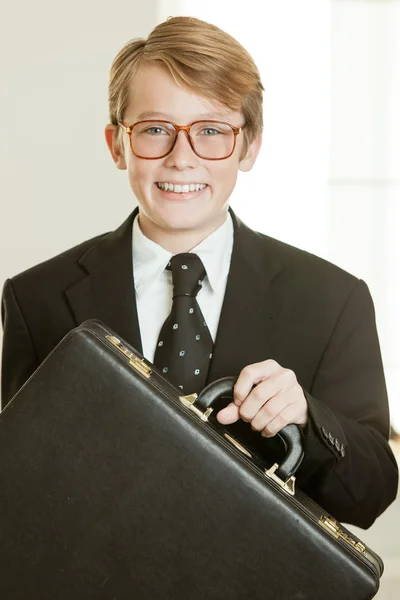 Smiling boy in business suit holding brief case