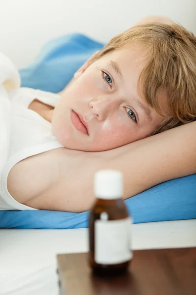 Beteg fiú mellett gyógyszer palackot megállapításáról — Stock Fotó