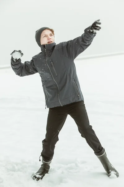 冬の日に雪玉を投げて 10 代の少年 — ストック写真