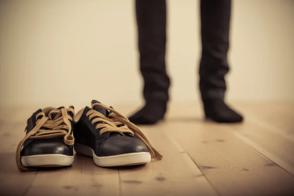 Person steht hinter Paar Schuhen auf Holzboden — Stockfoto