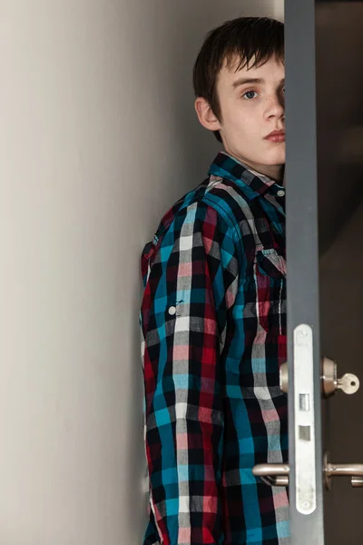 Teenage Boy Hiding Behind Open Door in Home — Stock Photo, Image