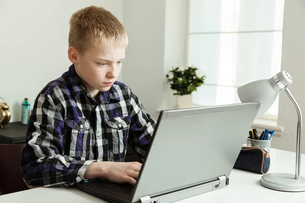 Mladí dospívající chlapec pomocí přenosného počítače na stůl — Stock fotografie