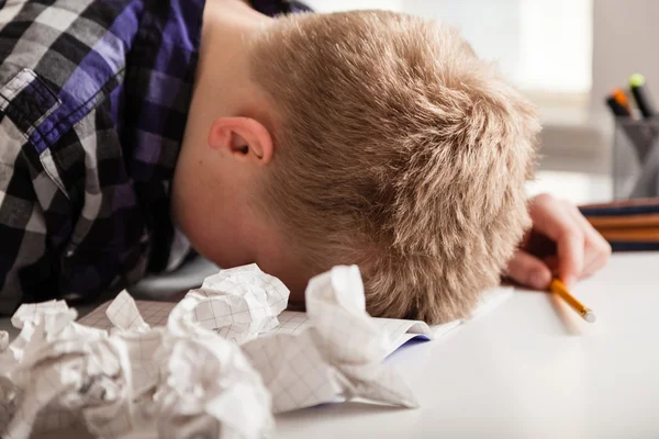 Young boy struggling with his homework