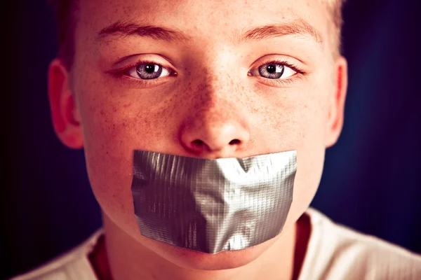 Kleiner Teenager Junge mit Klebeband, das den Mund bedeckt — Stockfoto