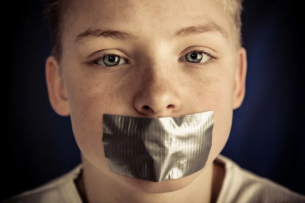 Kleiner Teenager Junge mit Klebeband, das den Mund bedeckt — Stockfoto