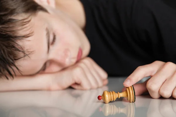 ポーンチェスピースを保持する眠っている十代の少年 — ストック写真