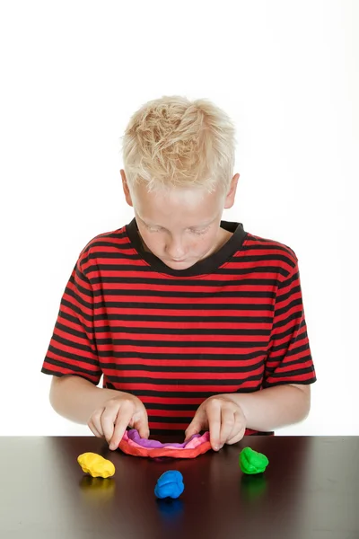 Creativo ragazzo che gioca con stucco di plastica — Foto Stock