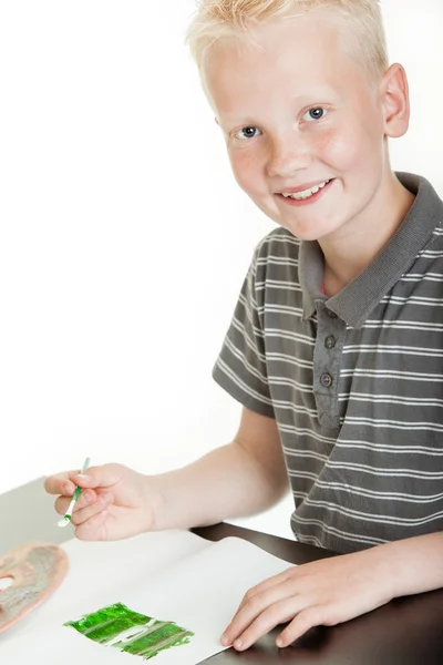 Sorrindo menino bonito sentado pintura — Fotografia de Stock