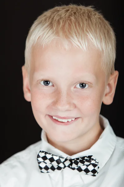Leende blond pojke bär rutig fluga — Stockfoto