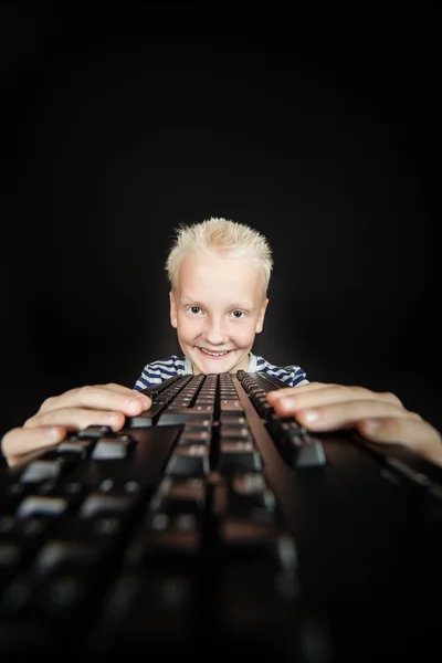 Sorridente giovane biondo tiene la tastiera in entrambe le mani — Foto Stock