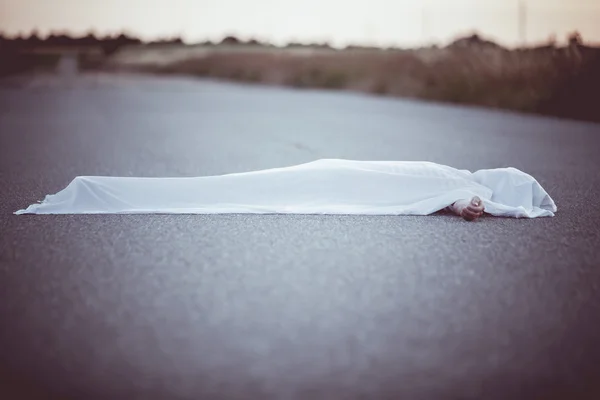 Dead body covered with sheet in middle of road — Stock Photo, Image