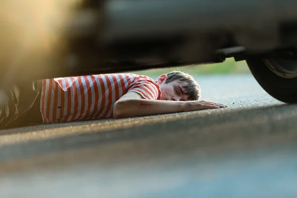 Hiere e inconsciente niño en asfalto —  Fotos de Stock