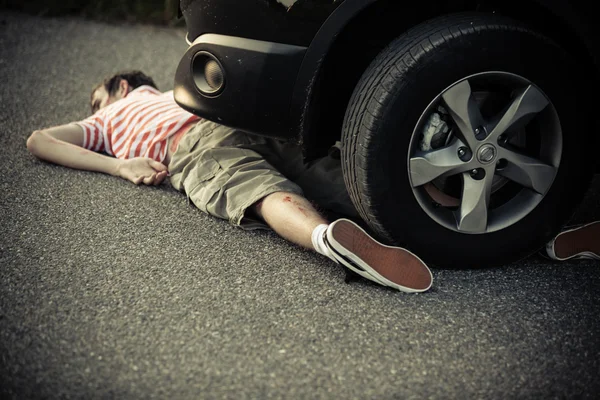Λάστιχο αυτοκινήτου και προφυλακτήρα πάνω από αναίσθητο αγόρι — Φωτογραφία Αρχείου